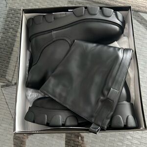 Black cleated knee high pocket boots